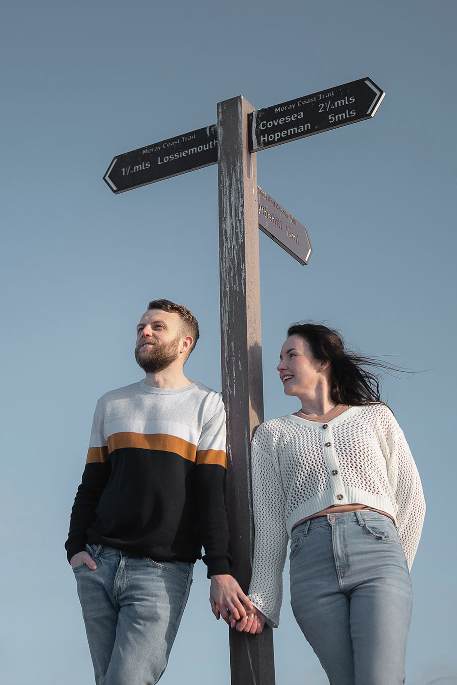 Couple standing next to path sign