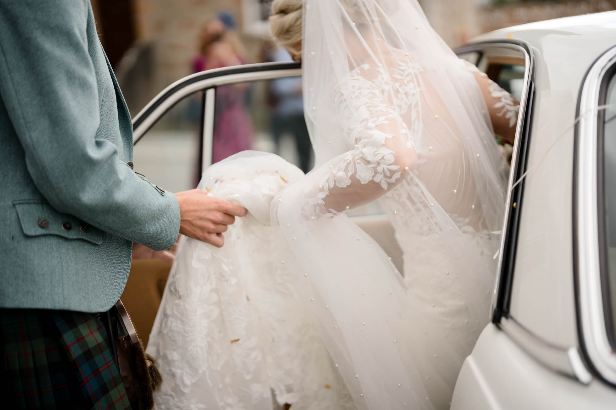 Bride getting in wedding car