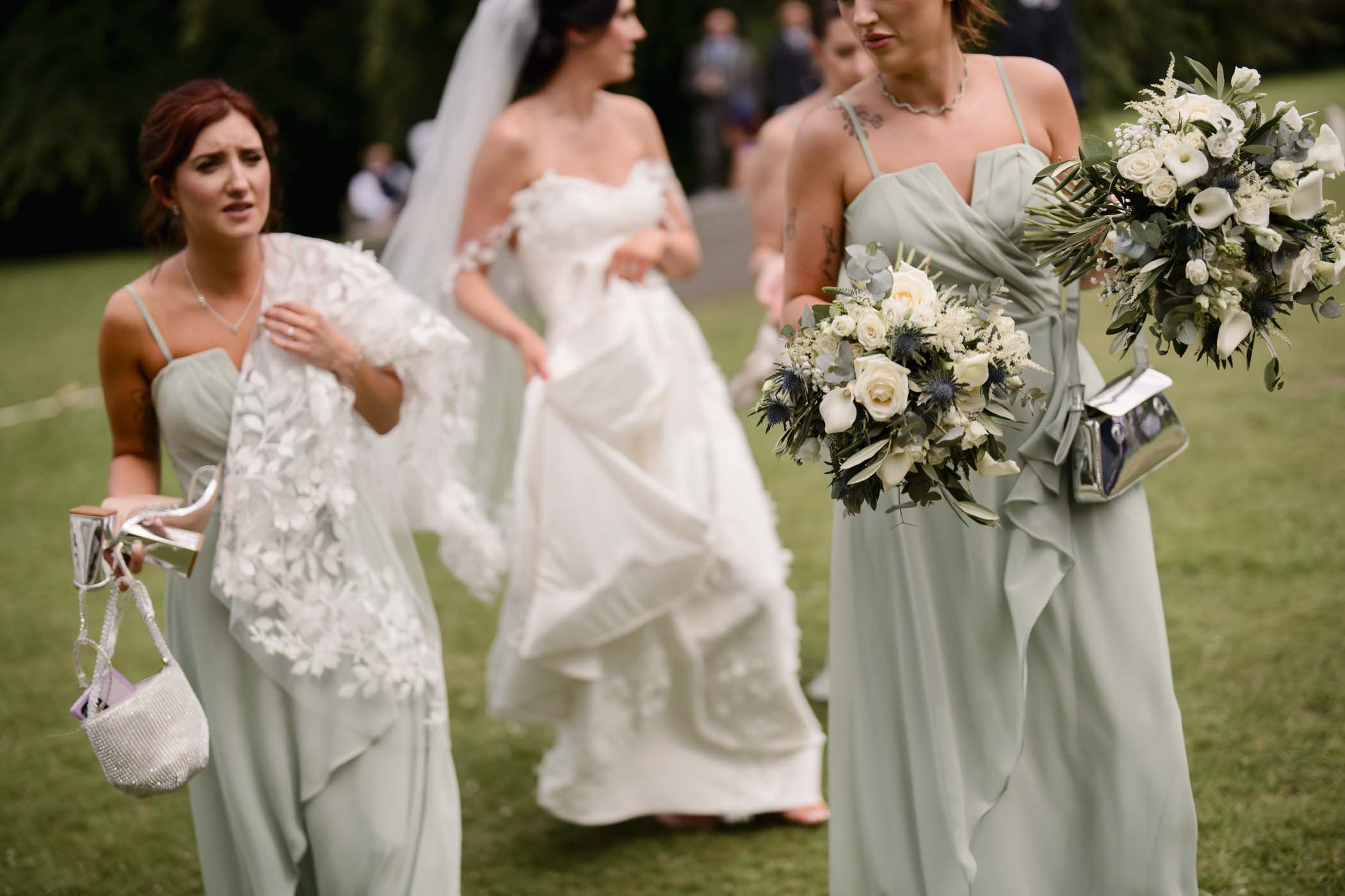 Bridesmaids holding bouquets, handbags and shoes at a Highland wedding in Scotland