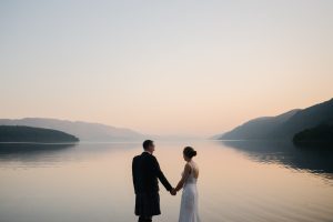 Couple standing at Loch Ness at sunset